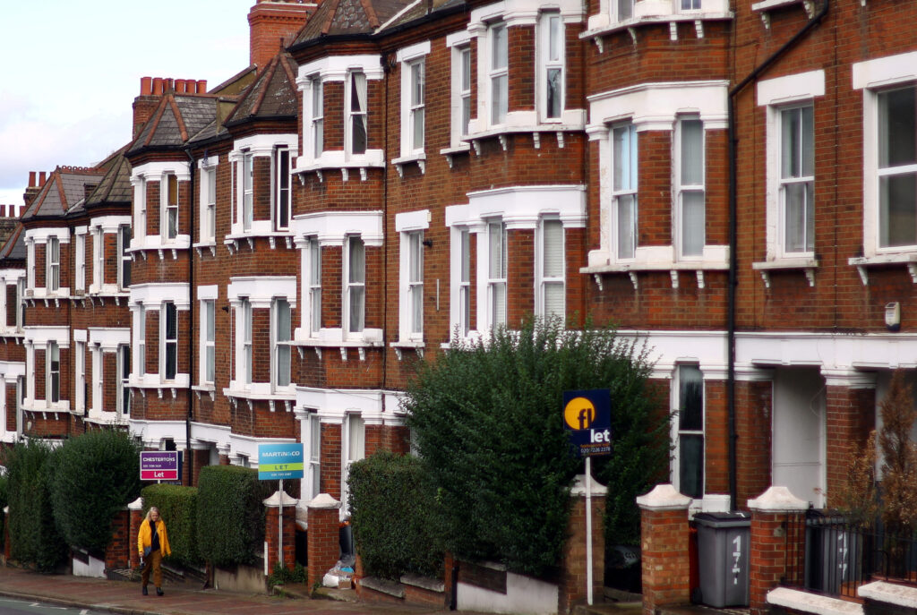 FILE PHOTO: A woman walks past houses ‘To Let’ in a residential street in London, Britain, September 27, 2022. REUTERS/Hannah McKay/File Photo